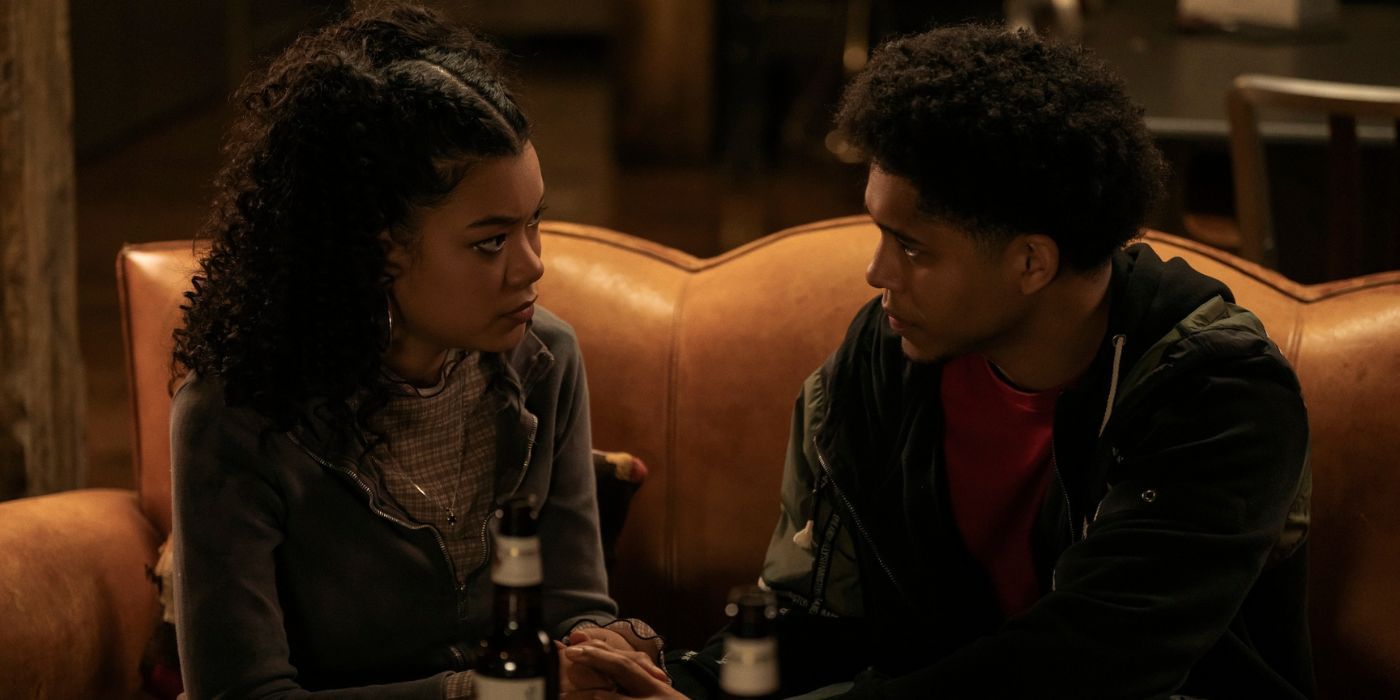 Anire Kim Amoda and Rhenzy Feliz sitting on a couch together as Graciela and Victor in The Penguin Episode 3.