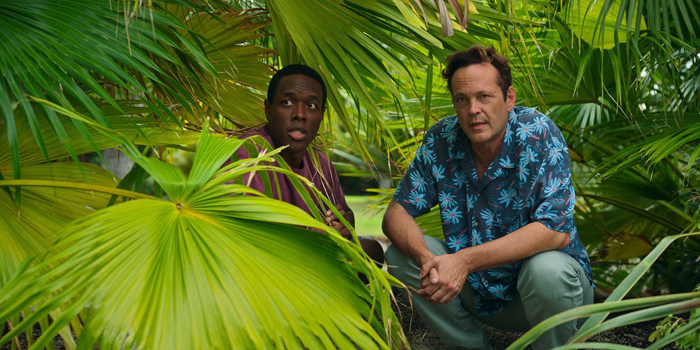 Vince Vaughn in Bad Monkey hiding behind a bush with another man.