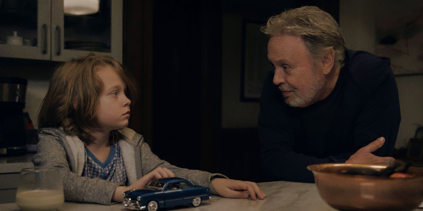 Billy Crystal and Jacobi Jupe sitting at a kitchen table and looking at each other in Before.