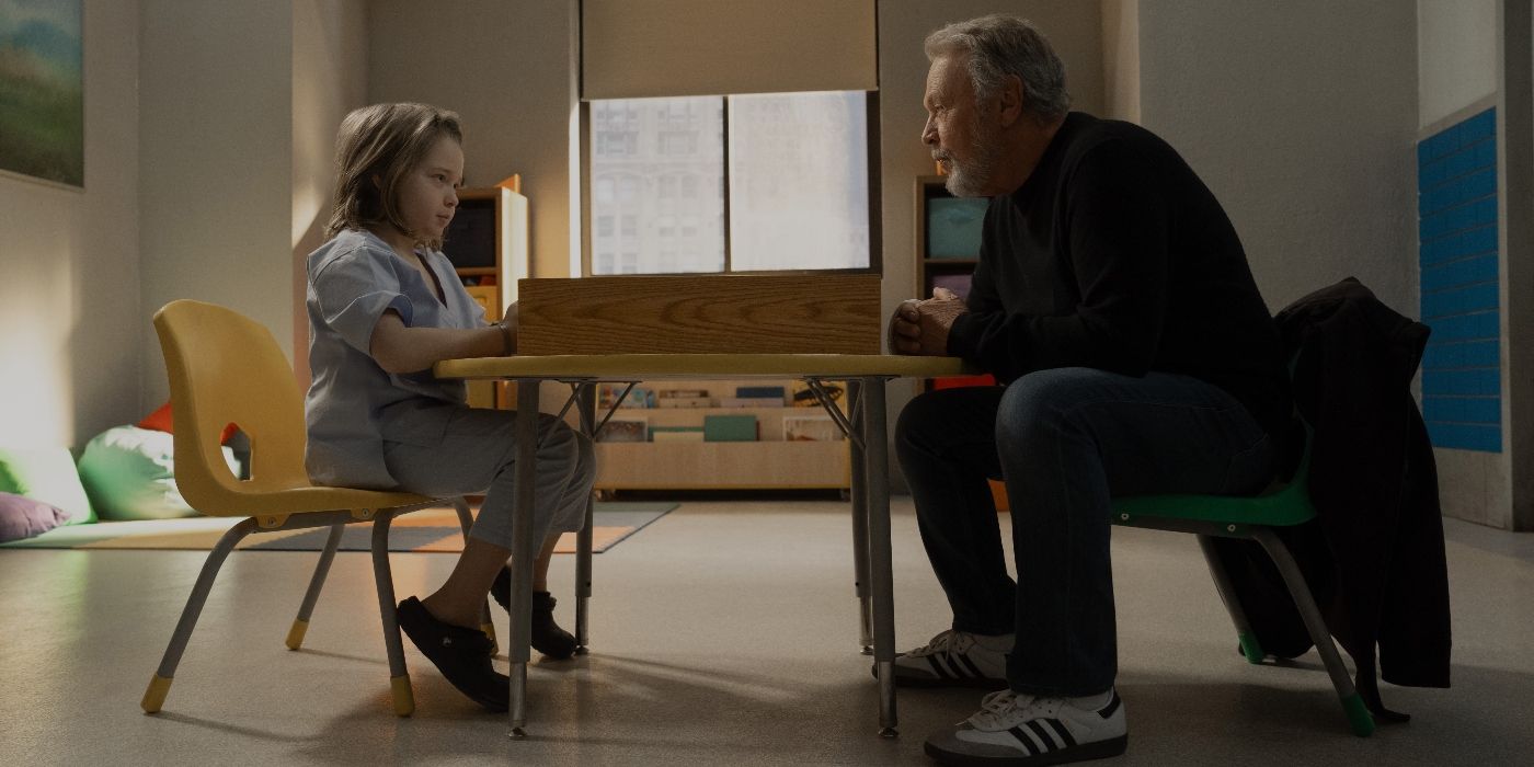 Jacobi Jupe and Billy Crystal sitting at a small table