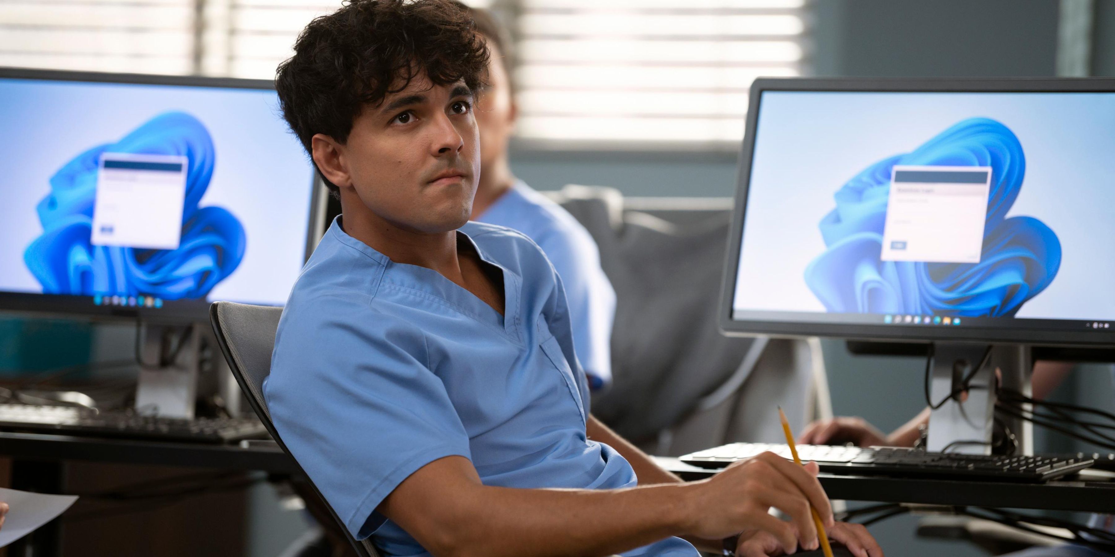 Niko Terho as Lucas Adams in Season 20 of 'Grey's Anatomy,' with his back to a computer and looking at something off-screen.