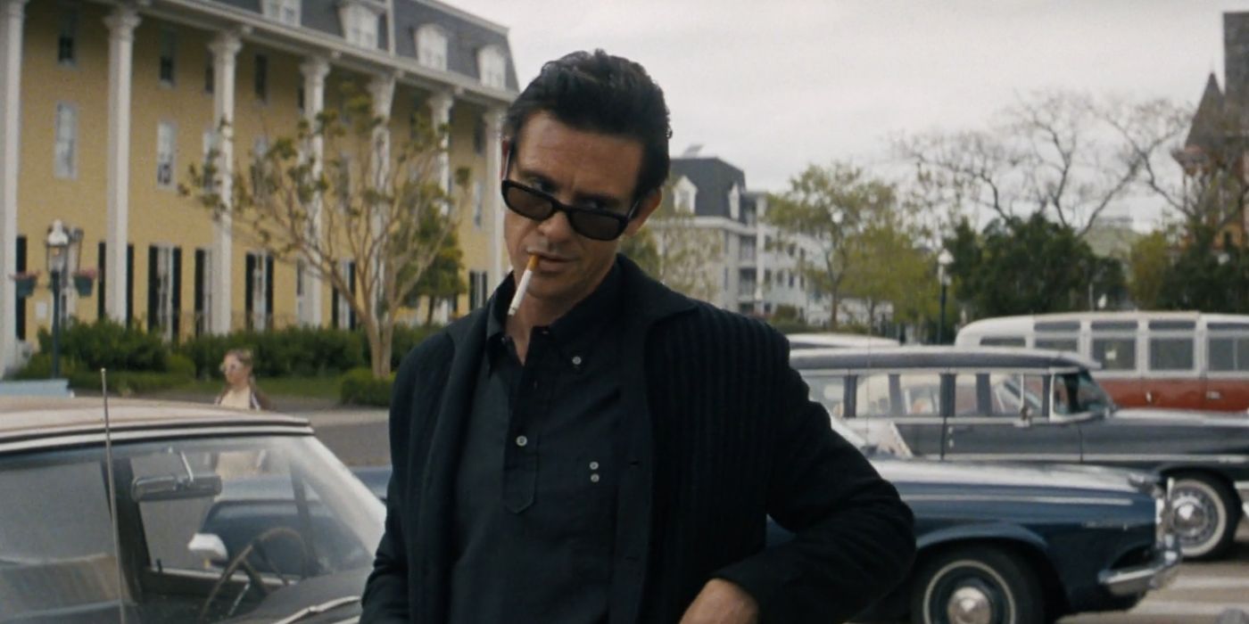 Boyd Holbrook as Johnny Cash leaning on a car, tipping his sunglasses, and smoking a cigarette in A Complete Unkown.