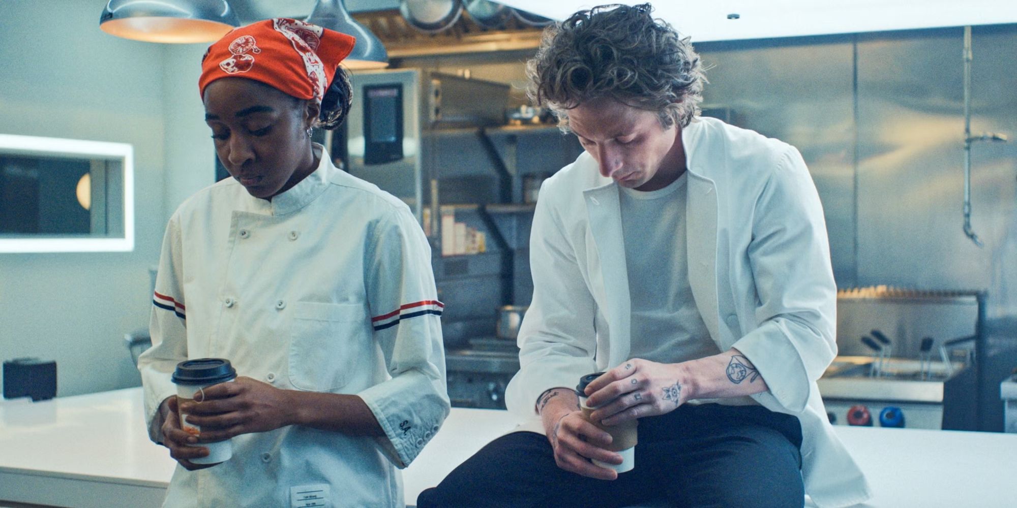 Jeremy Allen White as Carmy and Ayo Edebiri as Sydney side by side in the kitchen in Season 3 of The Bear.