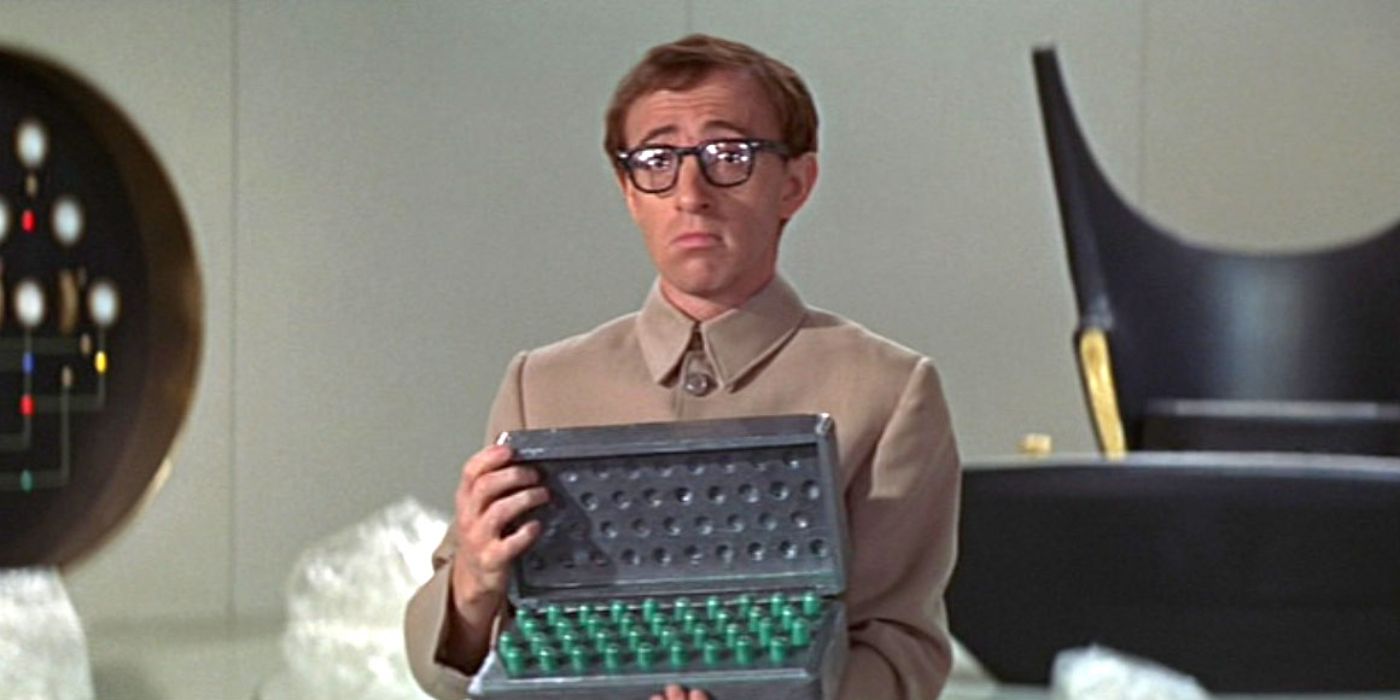 A confused-looking young man holds open a case filled with green vials in 'Casino Royale' (1967).