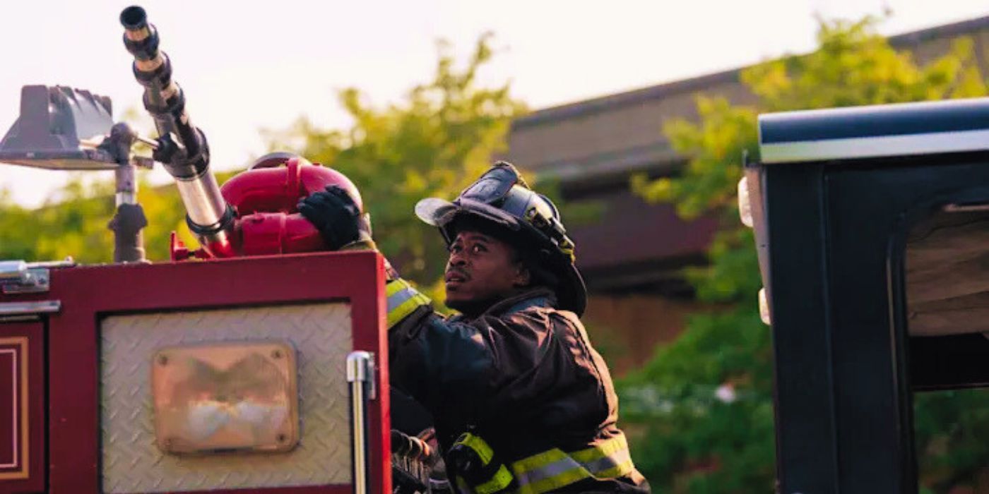 Firefighter Darren Ritter (Daniel Kyri) atop a firetruck, aiming a hose up in Chicago Fire