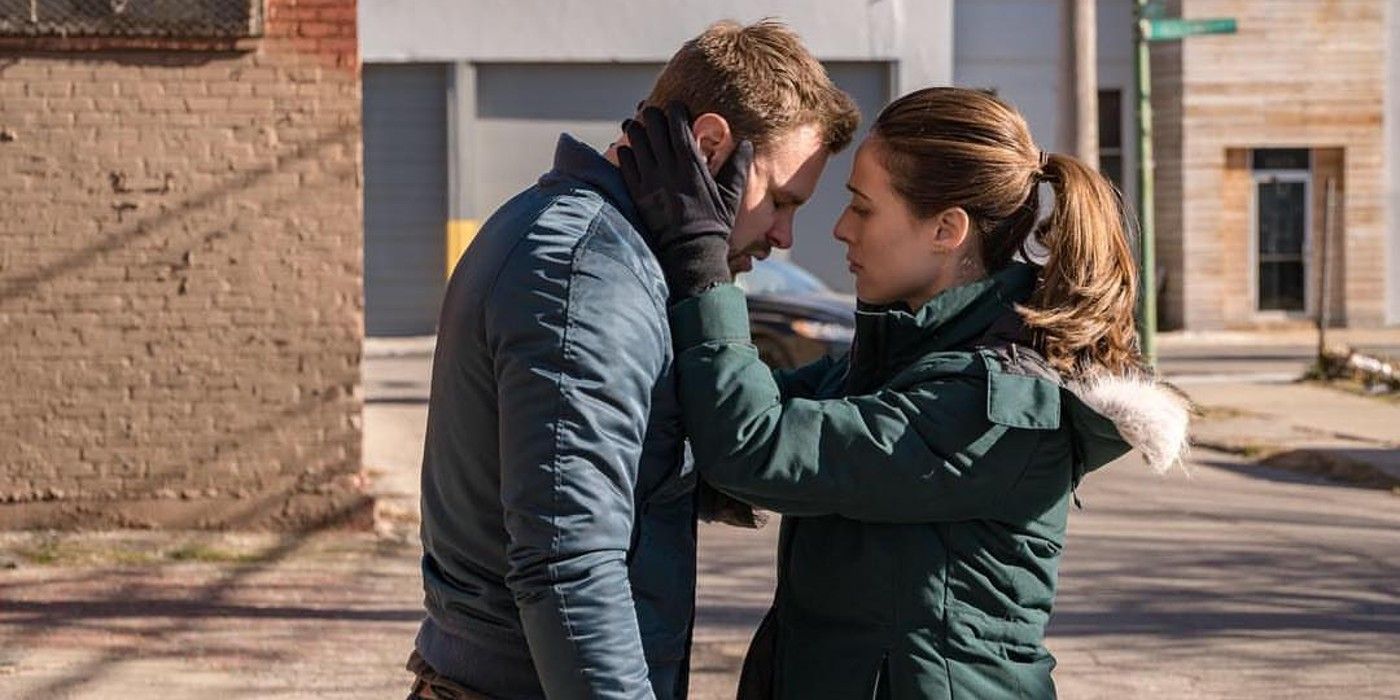 Kim comforts Adam, with her hands on his face, outside in Chicago PD