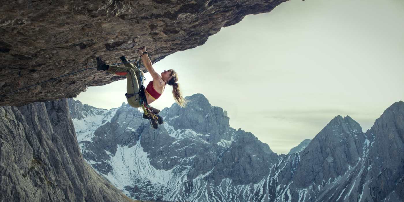 Lily James in Cliffhanger Reboot hanging from a cliff