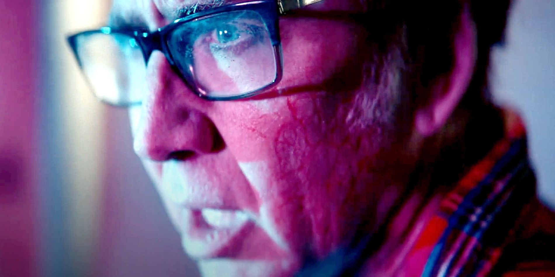 Nathan Gardner, played by actor Nicolas Cage, looks disturbed while bathed in purple light in Color Out Of Space.