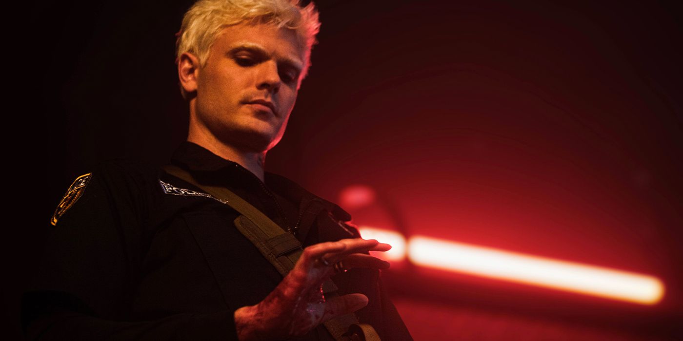 Alex Roe looking down at his bloody hand in Depravity
