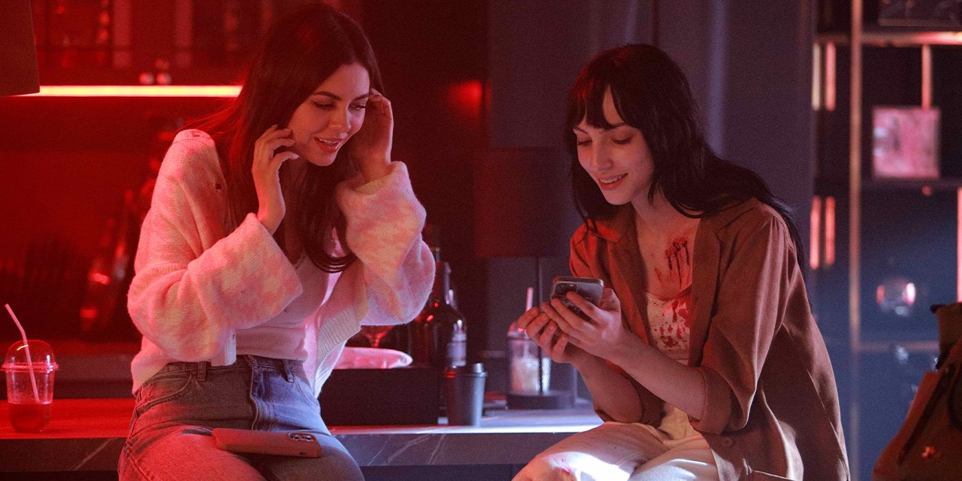 Victoria Justice sitting on a counter looking at Devon Ross' phone in Depravity