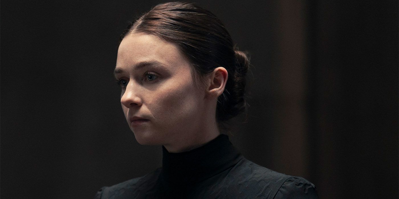 Jessica Barden as Young Valya in all black with a solemn expression