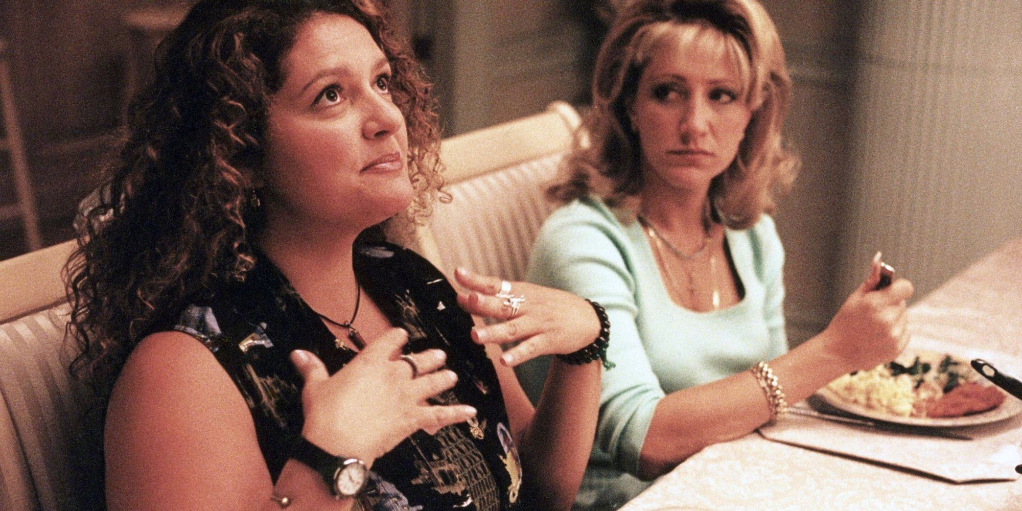 Edie Falco looking at Aida Turturro sitting next to her at the dinner table in The Sopranos_S2, E2