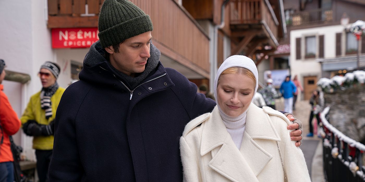 Gabriel and Camille walking down a street with Camille wearing a white turtleneck and hood in Emily in Paris