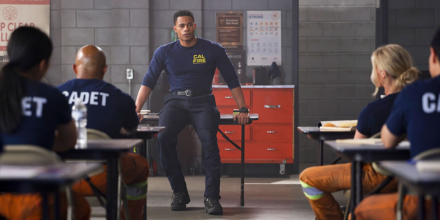 Jake sitting on a table in front of firefighter cadets in his CalFire shirt in Fire Country Season 3