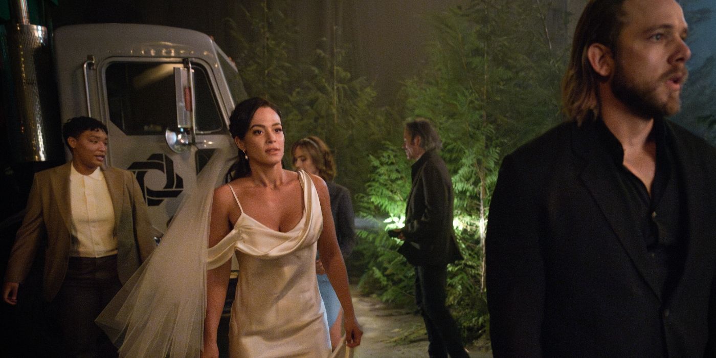 Max Thieriot as Bode standing in front of Stephanie Arcila in her wedding dress in Season 3 of Fire Country