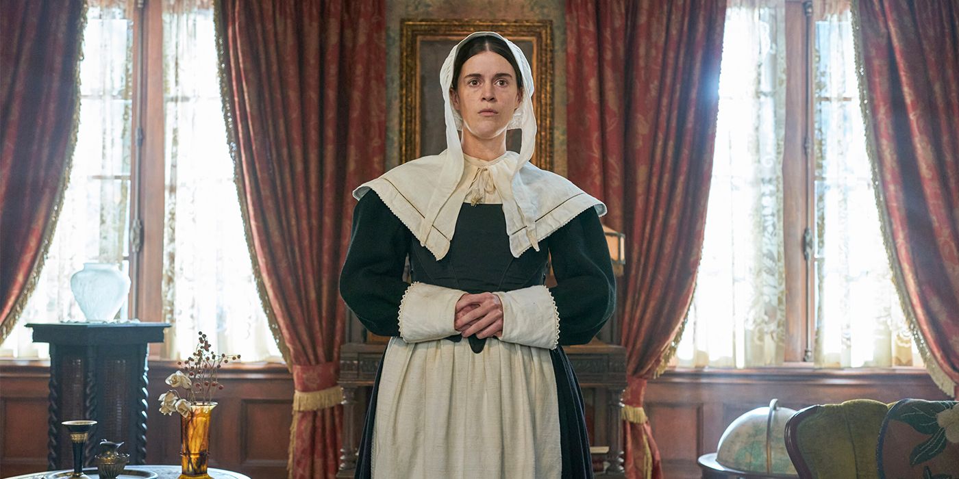 Mary Holland as Patience, a Puritan ghost, standing in a fancy room in CBS sitcom Ghosts