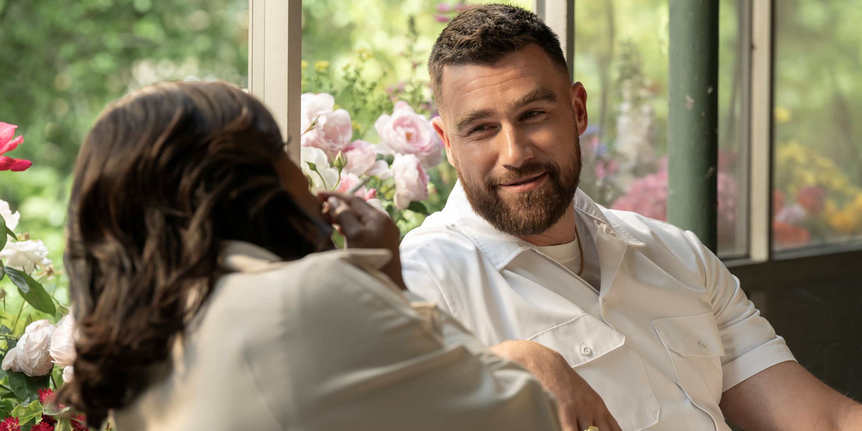 Travis Kelce in all white sitting next to Niecy Nash-Betts in the hospital in Grotesquerie