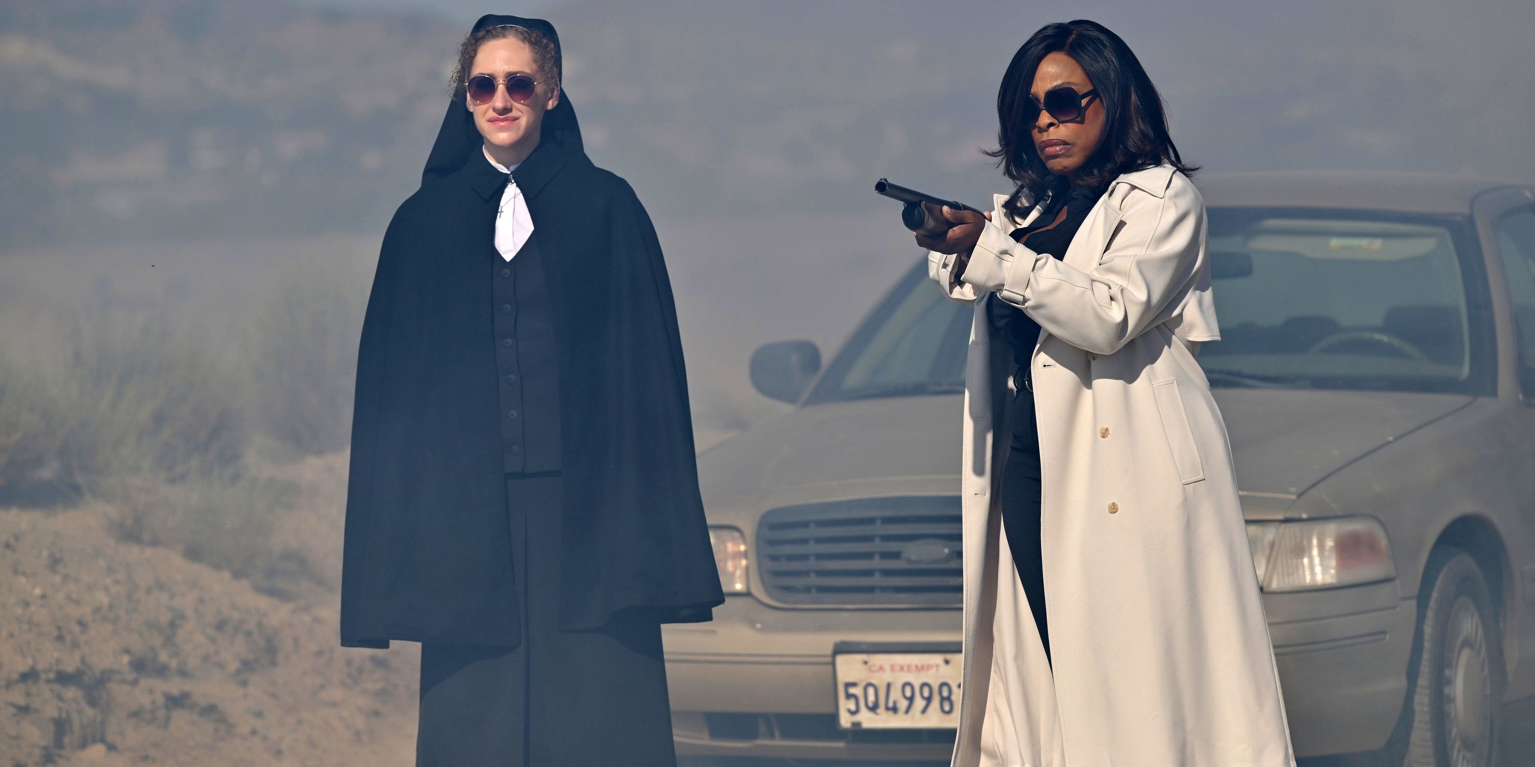 Niecy Nash-Besh as Det. Lois Tryon holding up a gun next to Micaela Diamond as Sister Megan in Grotesquerie