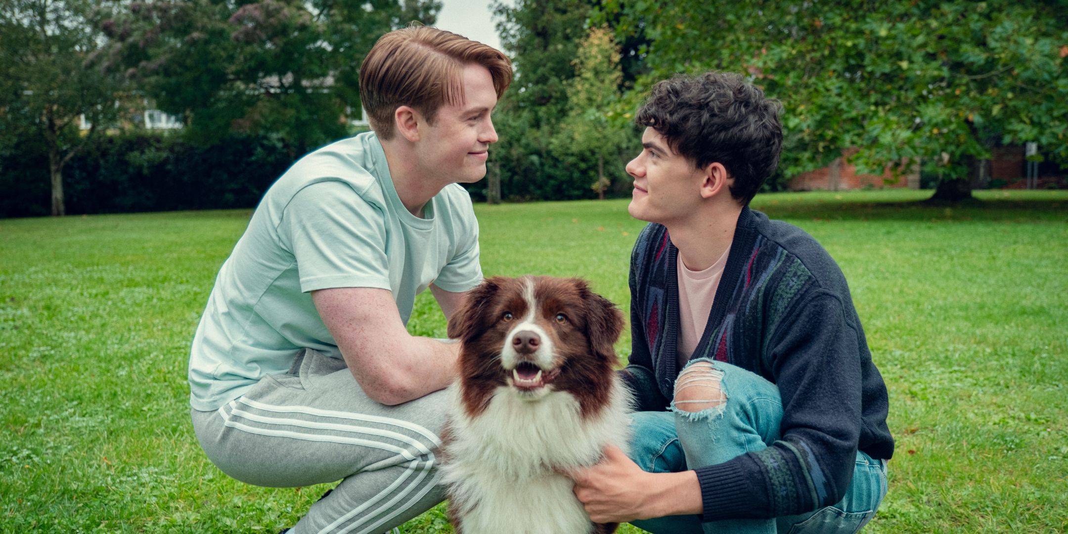 Kit Connor kā Niks un Džo Loks kā Čārlijs ar suni parkā HeartStopper S3E7.