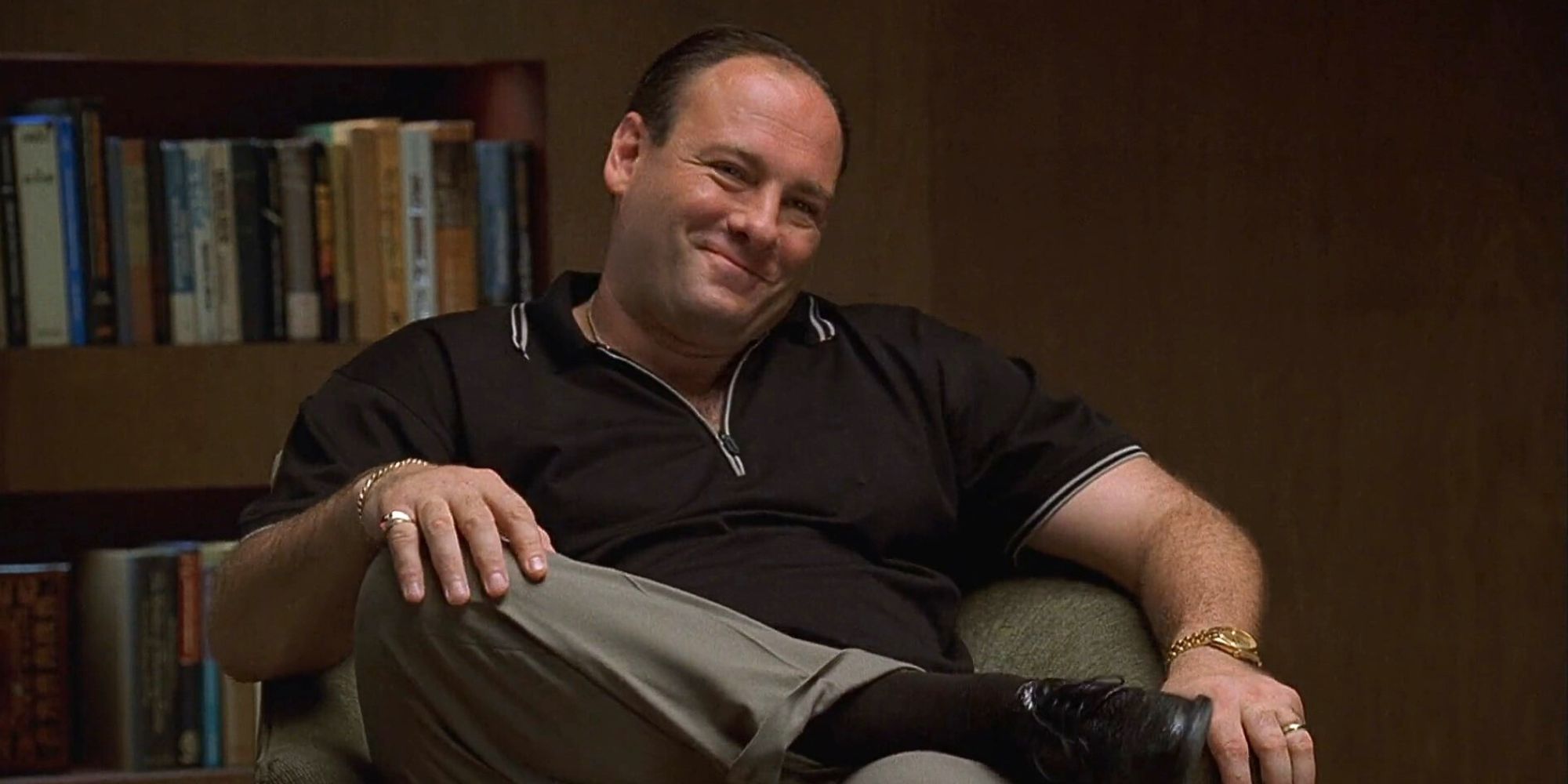 James Gandolfini sits in a chair in Dr. Melfi's office smiling in The Sopranos episode Big Girls Don't Cry