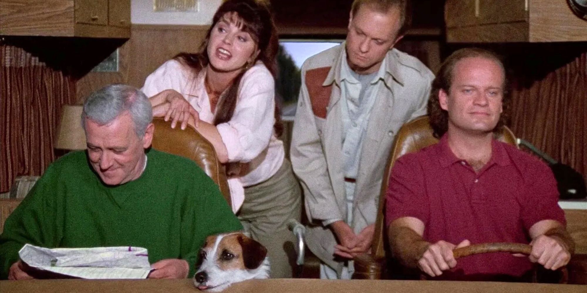 John Mahoney sitting in the passenger seat of an RV with his dog Eddie, Jane Leeves standing behind his seat, David Hyde Pierce standing next to her and behind Kelsey Grammer who is in the drivers seat driving in Frasier