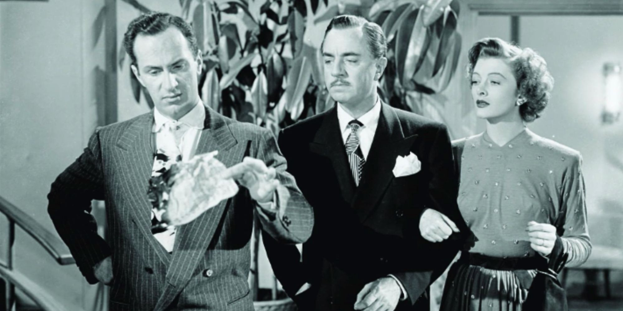 Keenan Wynn sostiene un papel enrollado con William Powell y Myrna Loy en 