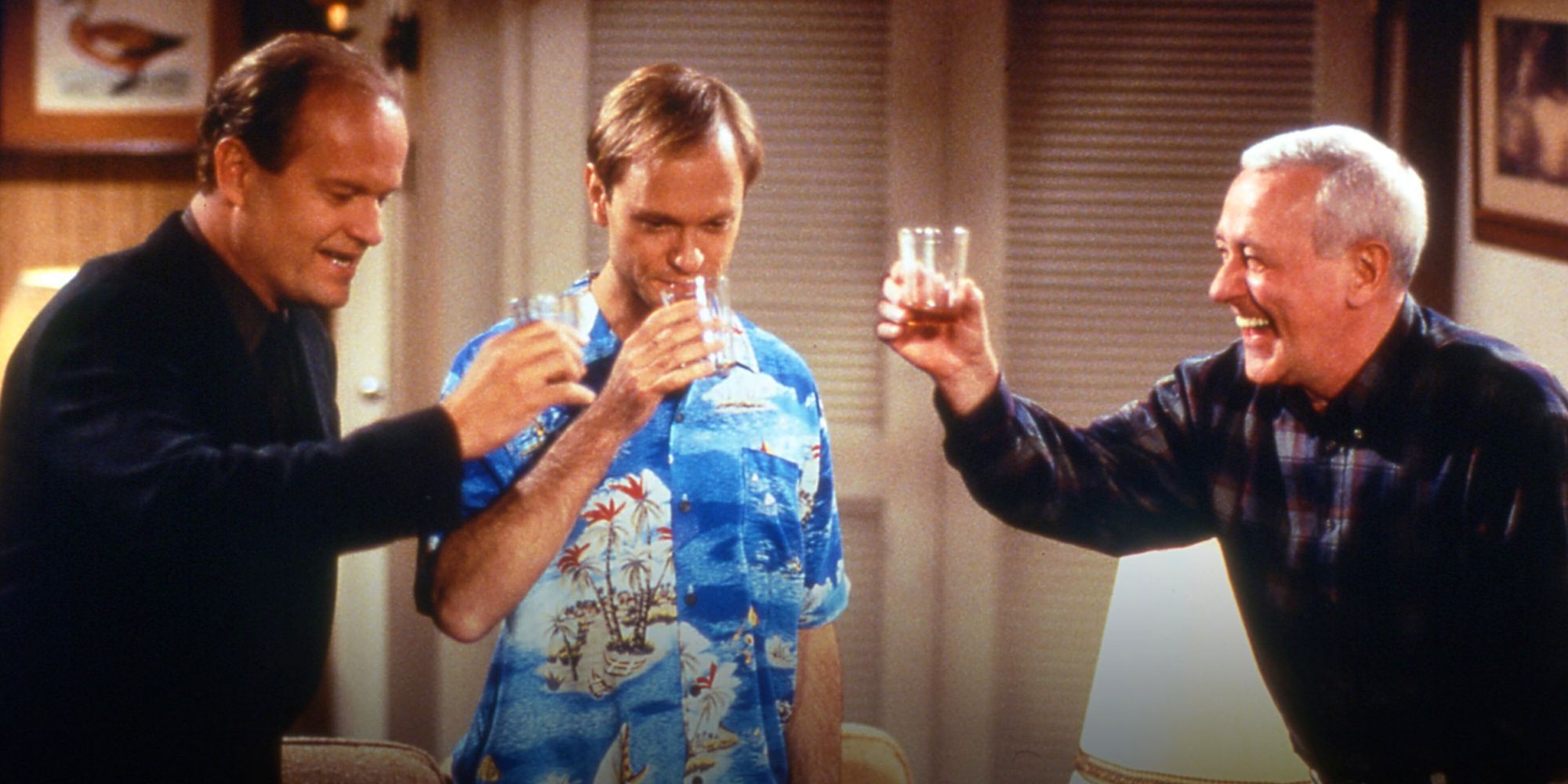 Kelsey Grammer, David Hyde Pierce and John Mahoney standing in a circle toasting in Frasier