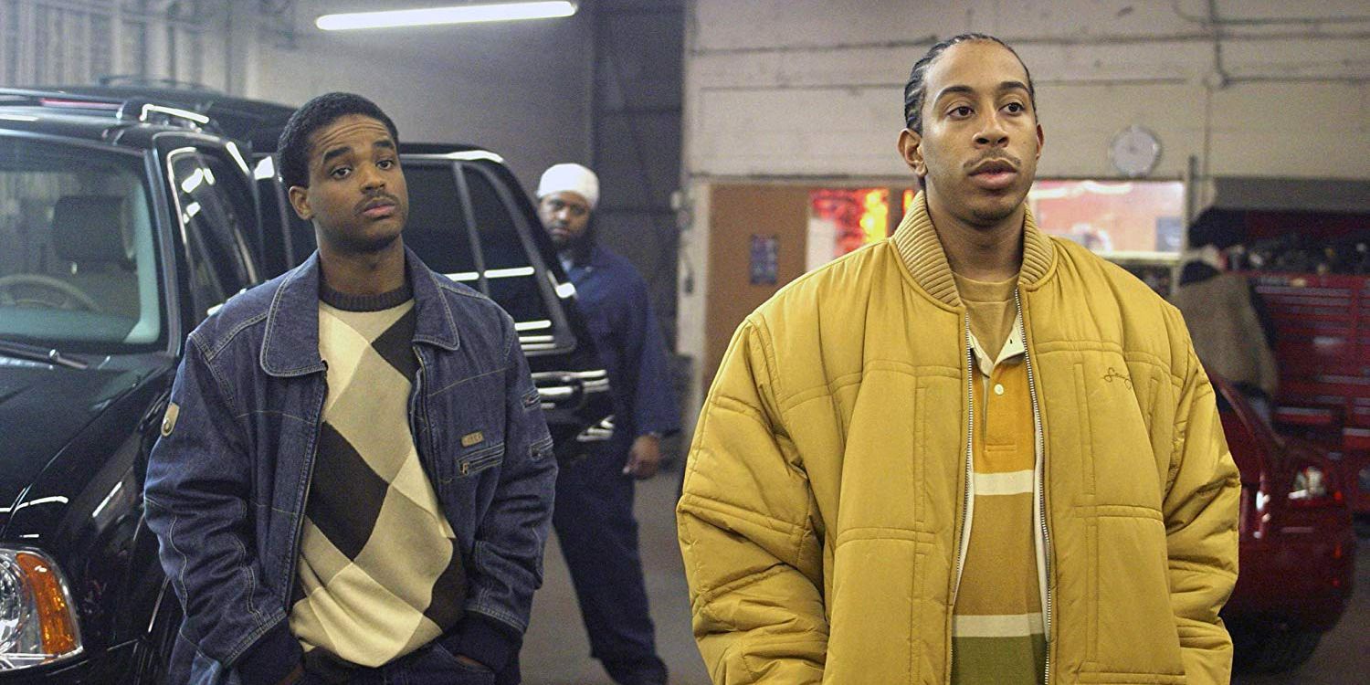 Larenz Tate, Ludacris, and Ime Etuk in a garage next to a van in Crash.
