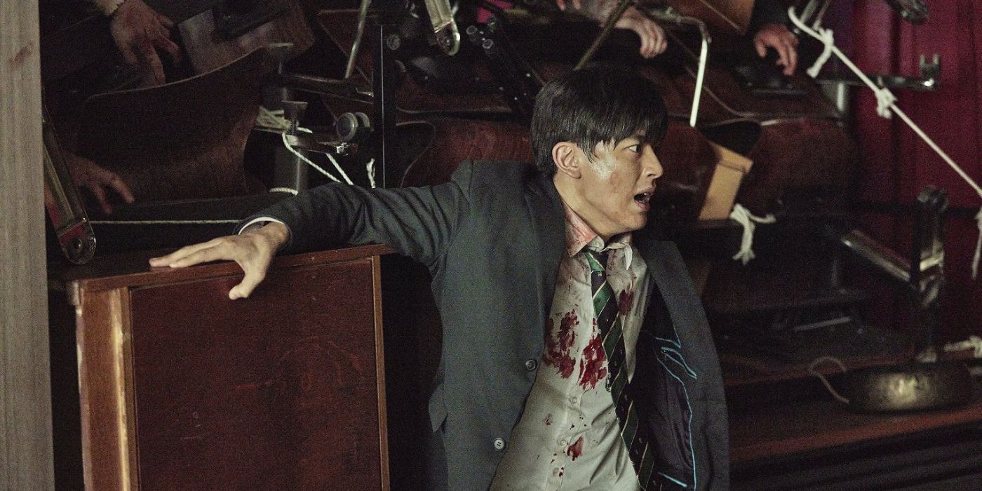 Lee Su-hyeok holds back a mountain of school furniture with zombies climbing over it