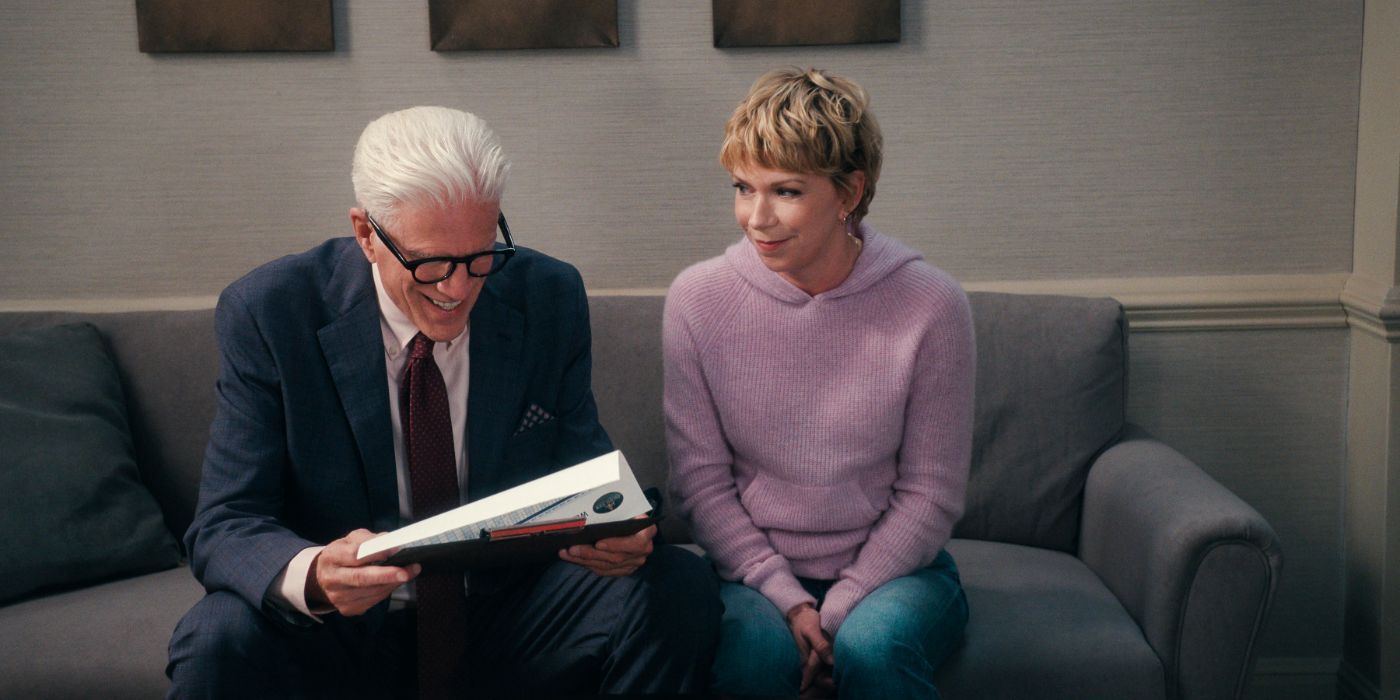 Ted Danson wears a suit and laughs at a paper while sitting next to Mary Elizabeth Ellis in a purple shirt