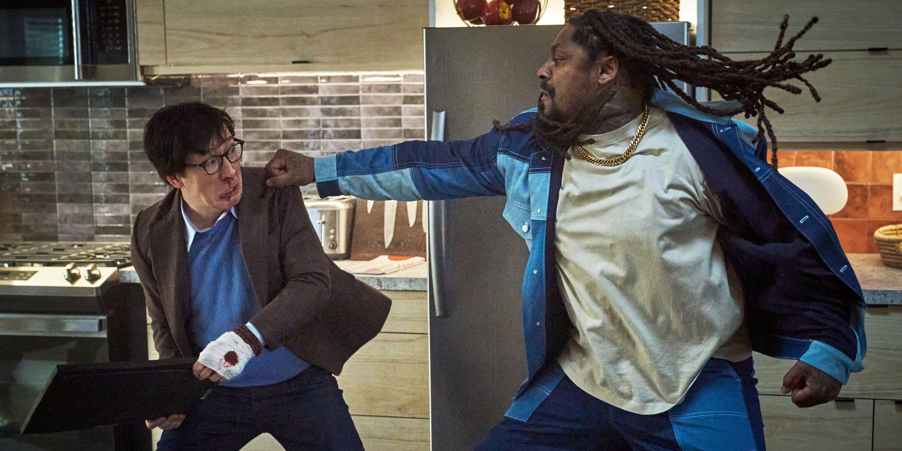 Ke Huy Quan as Marvin Gable in the kitchen dodging a punch from Marshawn Lynch as King in Love Hurts