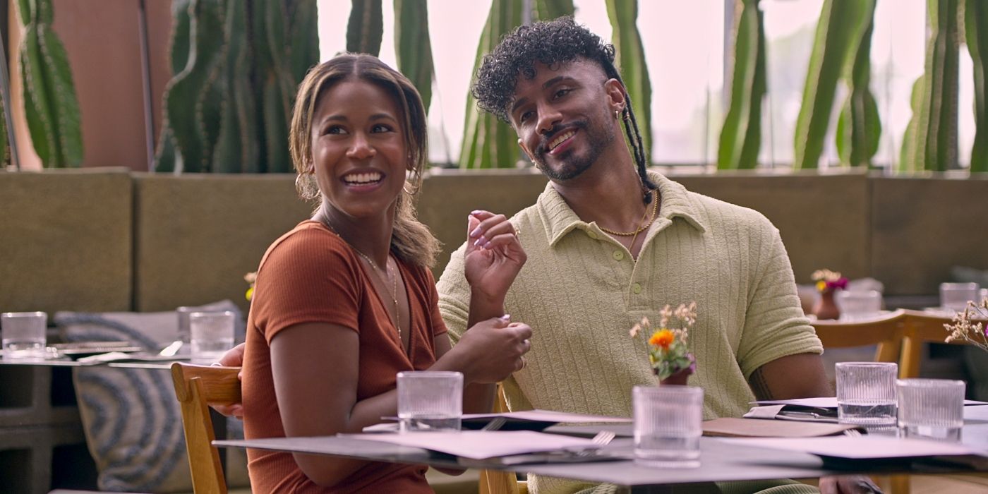 Marissa George and Ramses Prashad smile at an outdoor dining table in 'Love Is Blind'