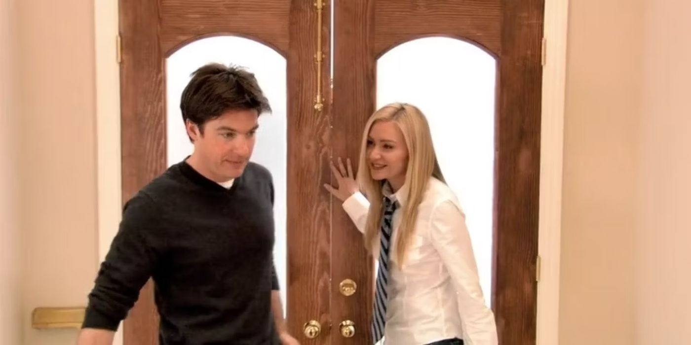 Jason Bateman and Portia de Rossi stand near a front door inside a house in Arrested Development.