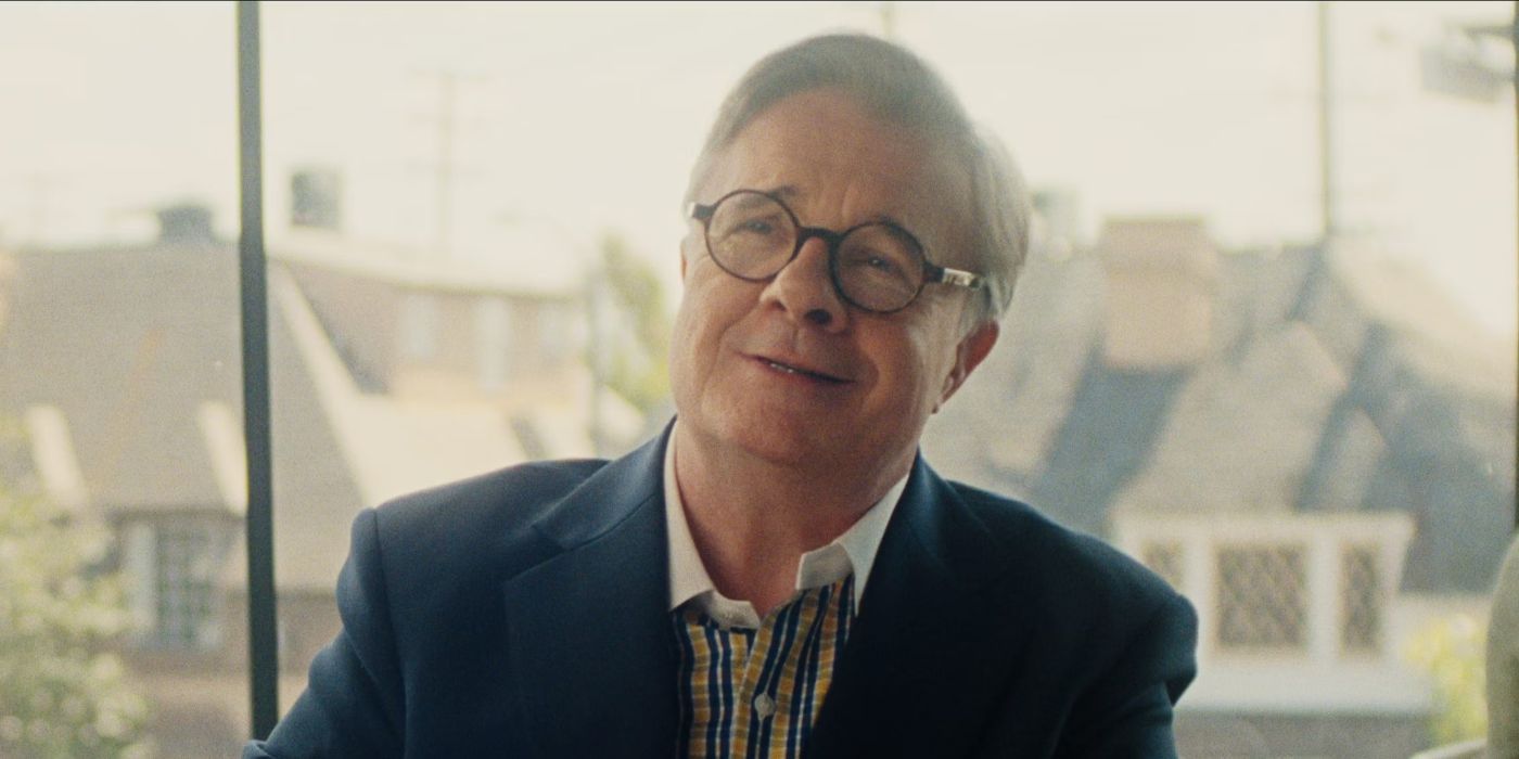 Nathan Lane sonríe como Dominic Dunne en 