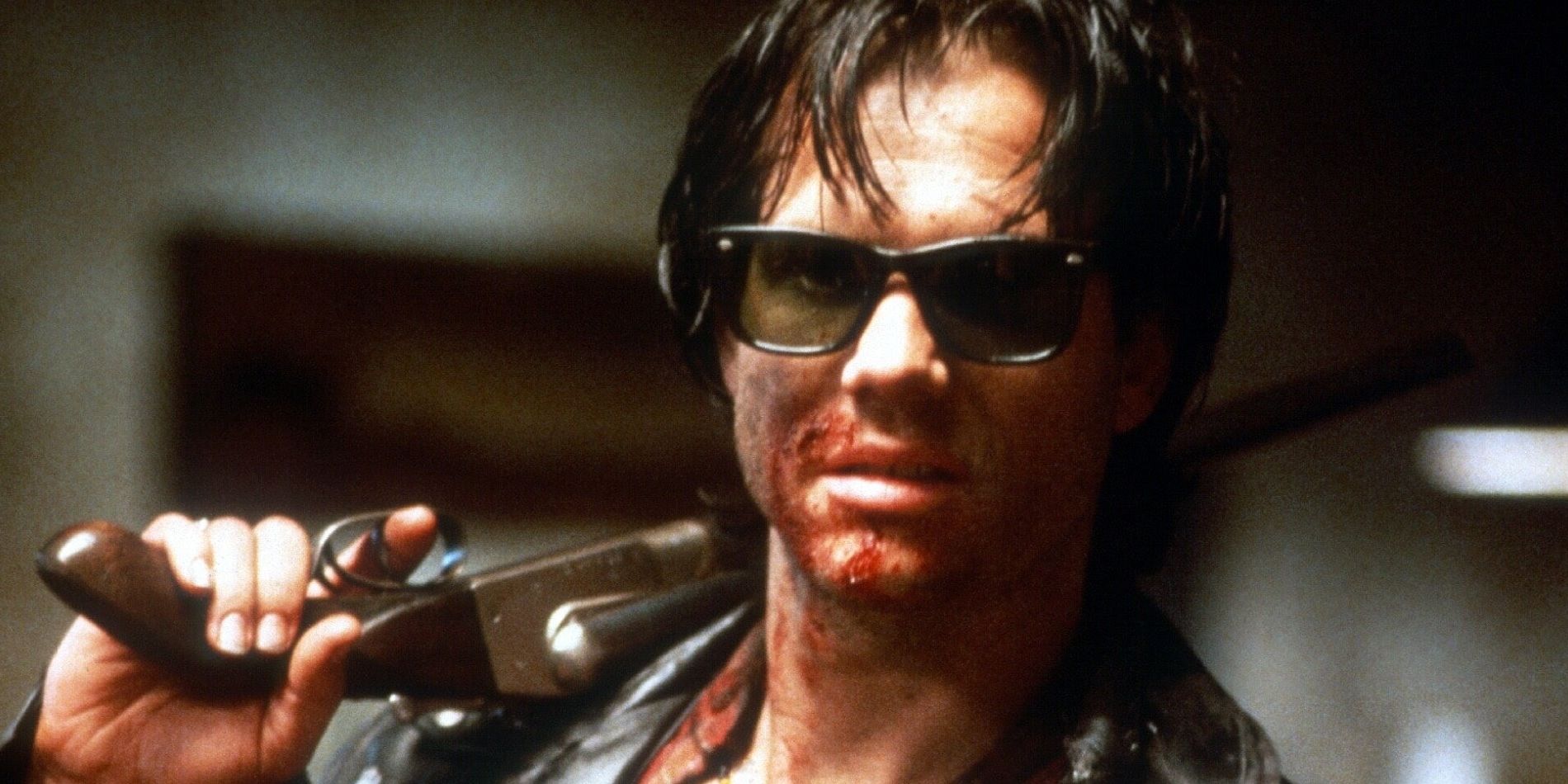 Severen, played by actor Bill Paxton, wearing sunglasses and holding a gun over his shoulder