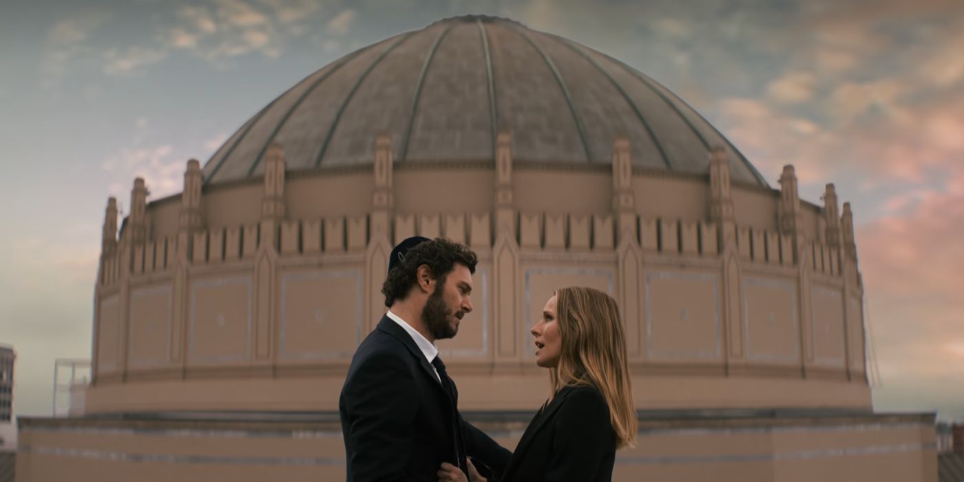 Noah (Adam Brody) wearing a tuxedo and Joanne (Kristen Bell) wearing a blazer in front of a temple in Nobody Wants This