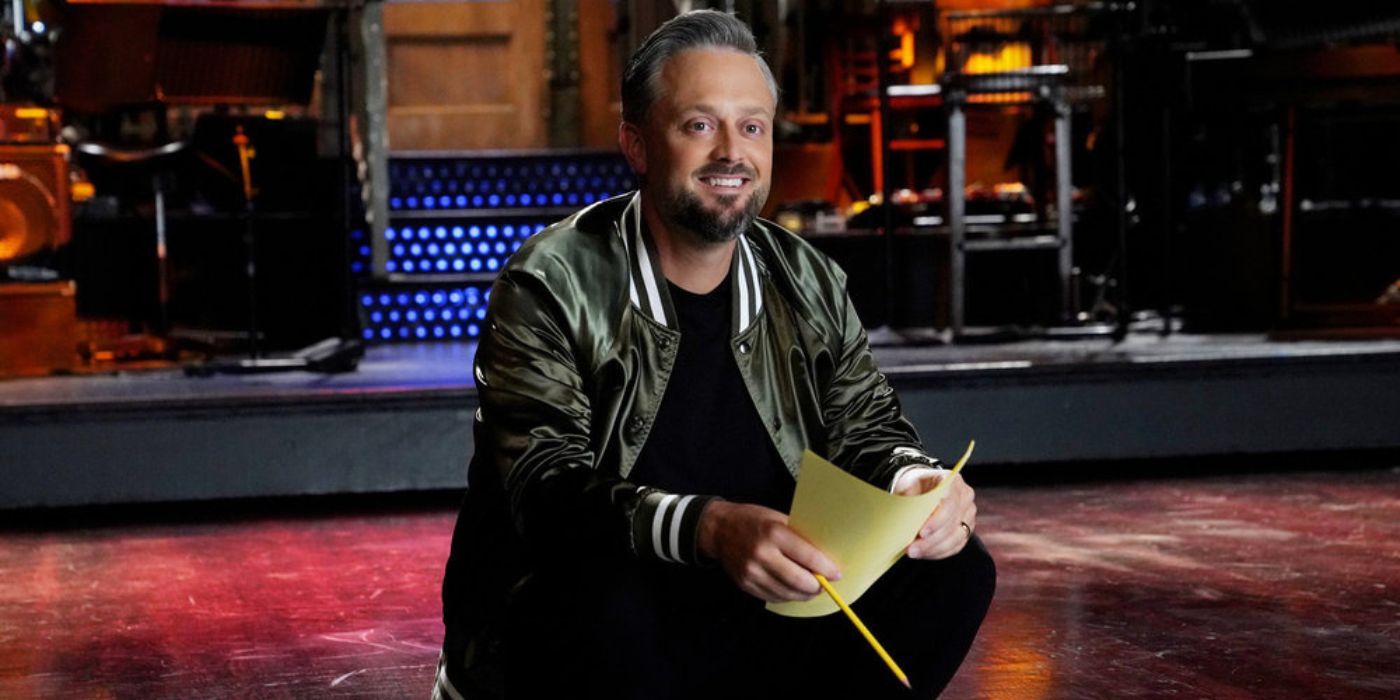 Nate Bargatze holding a yellow piece of paper and a pencil on the set of SNL.