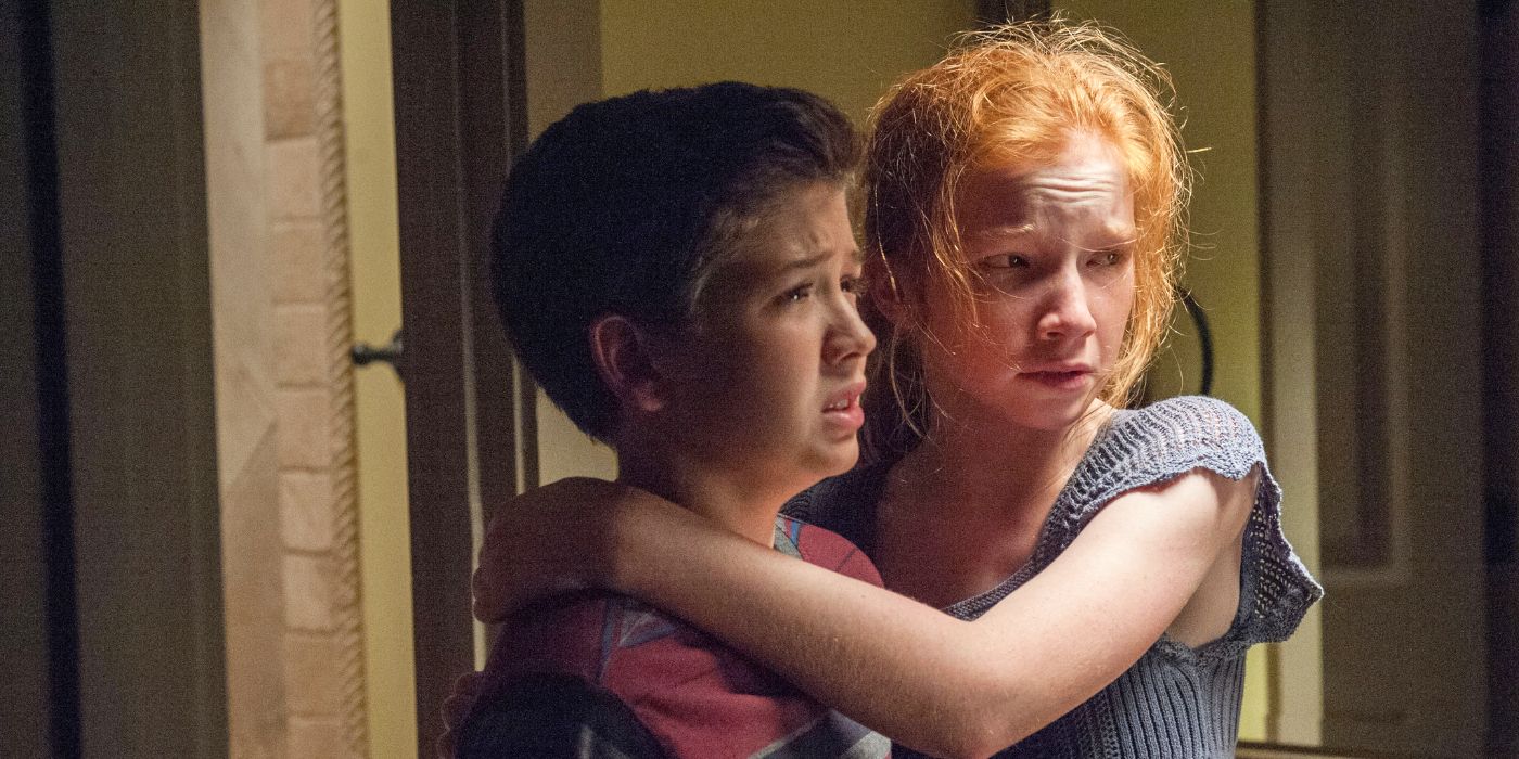 A young Kaylie and Tim clinging to each other looking scared and upset in Oculus.