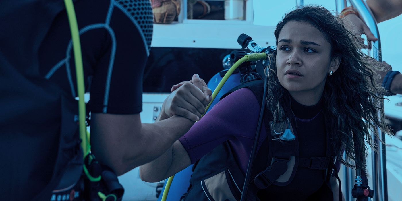 Madison Bailey as Kiara in scuba gear and holding someone's hand while looking to the side in Outer Banks Season 4 Part 1