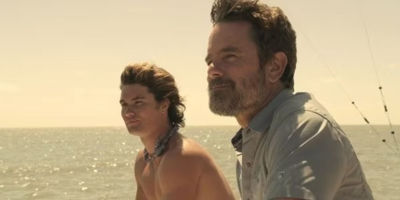 Two of the cast stare into the distance with water in the background in Outer Banks.