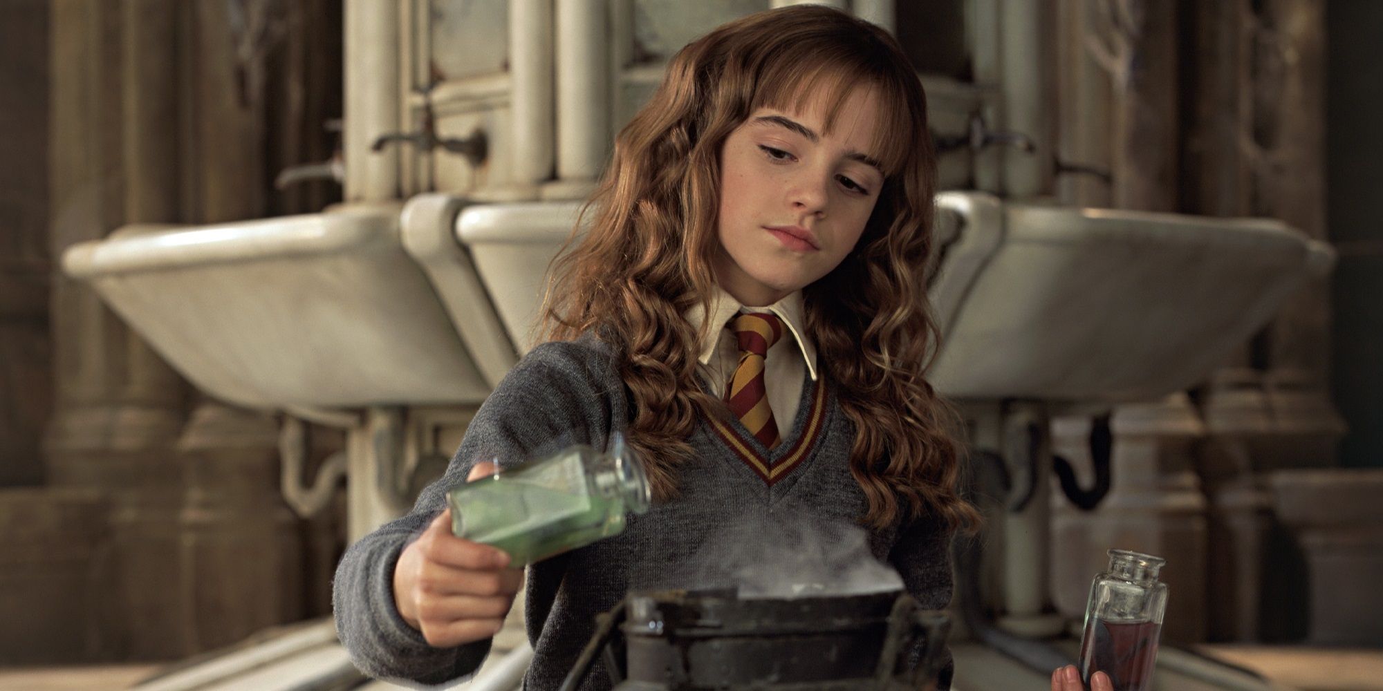 Hermione (Emma Watson) sits in a bathroom brewing Polyjuice Potion in Harry Potter and the Chamber of Secrets