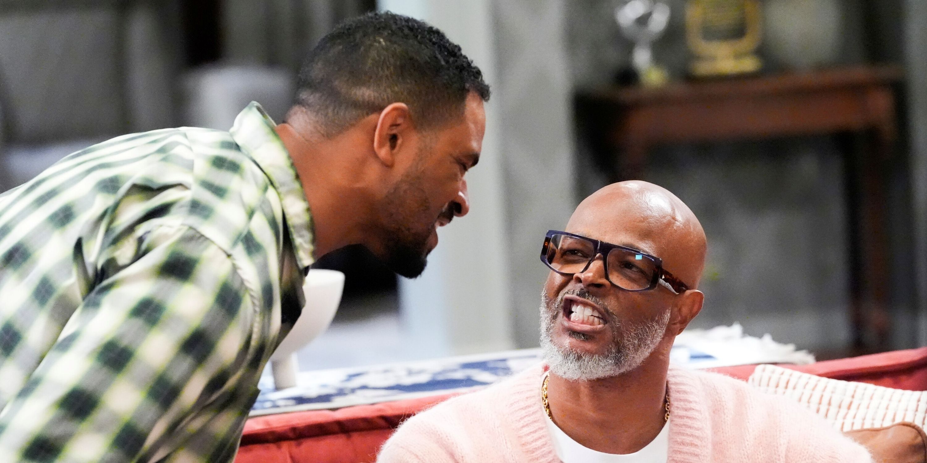 Damon Wayans Jr. leaning over Damon Wayans Sr. baring his teeth on the couch in Poppa's House