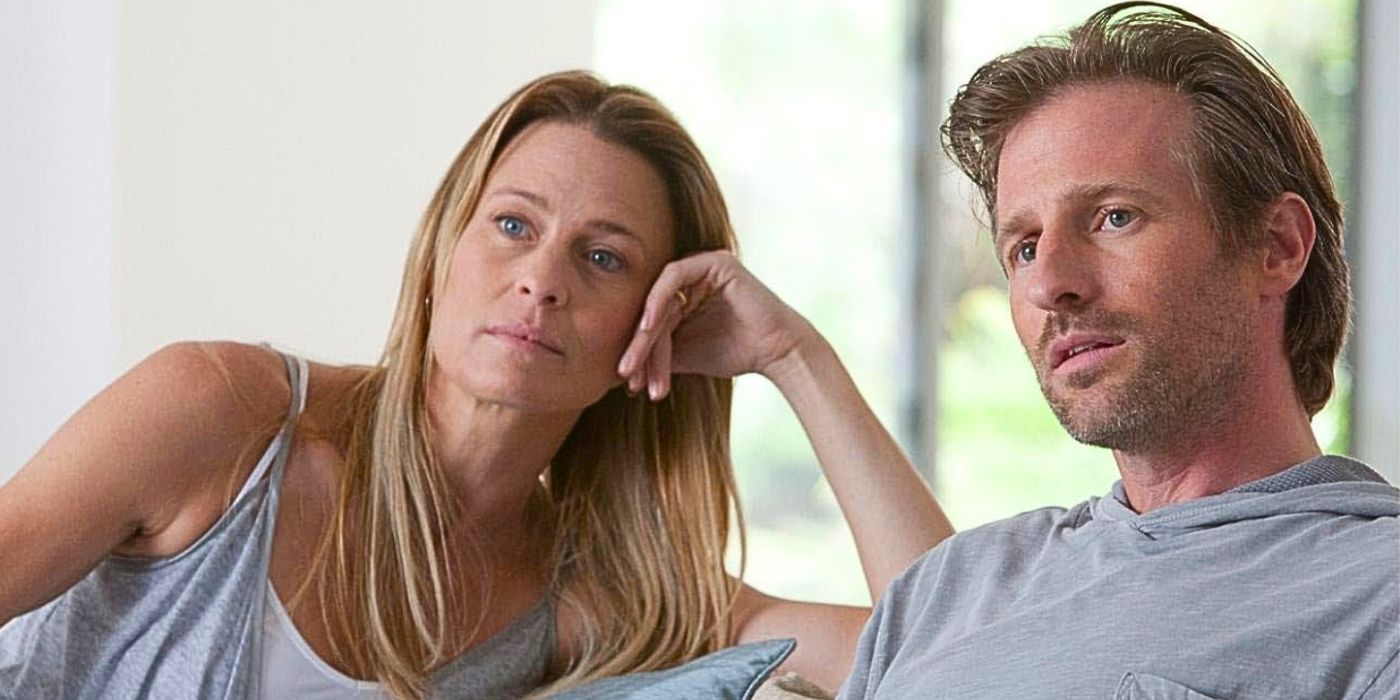Robin Wright sits next to Spike Jonze with her head propped up by her hand as they listen to someone speaking off-camera from the movie Moneyball
