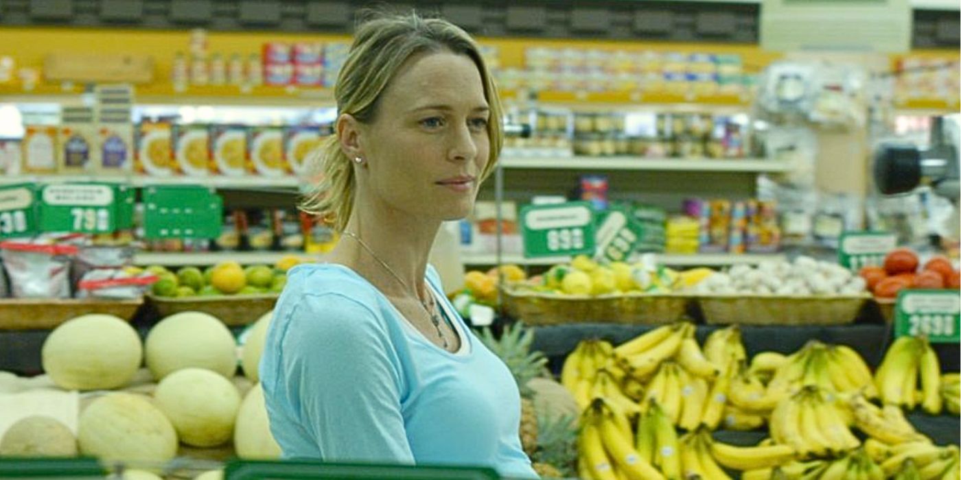 Robin Wright wears a light blue blouse at a supermarket as she stands in the produce section looking off-screen with a thoughtful expression from the movie Nine Lives