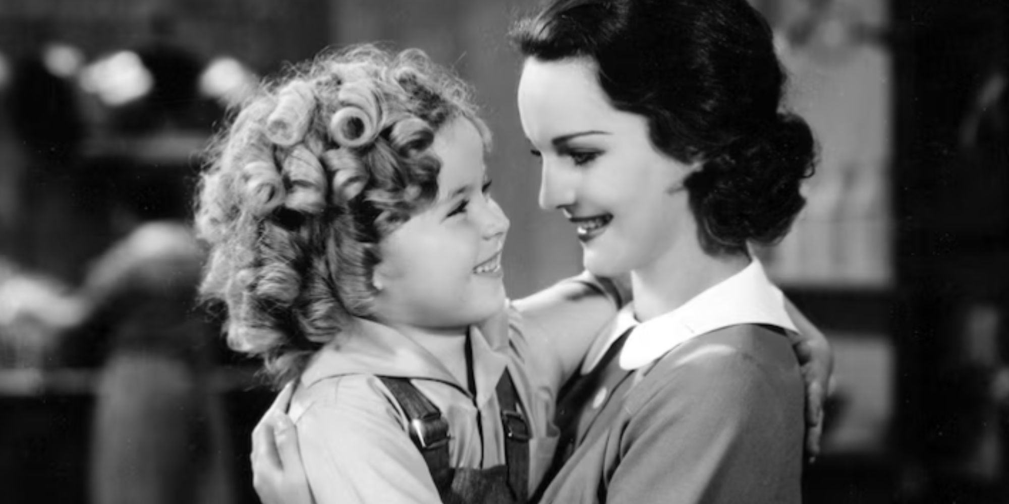 Rochelle Hudson holding Shirley Temple both looking at each other in Curly Top (1935)