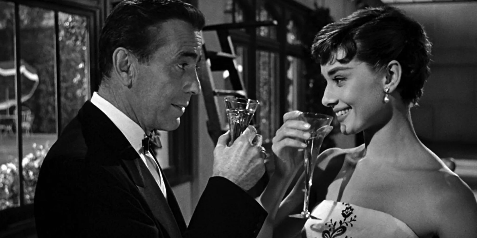 Audrey Hepburn and Humphrey Bogart in Sabrina toasting.