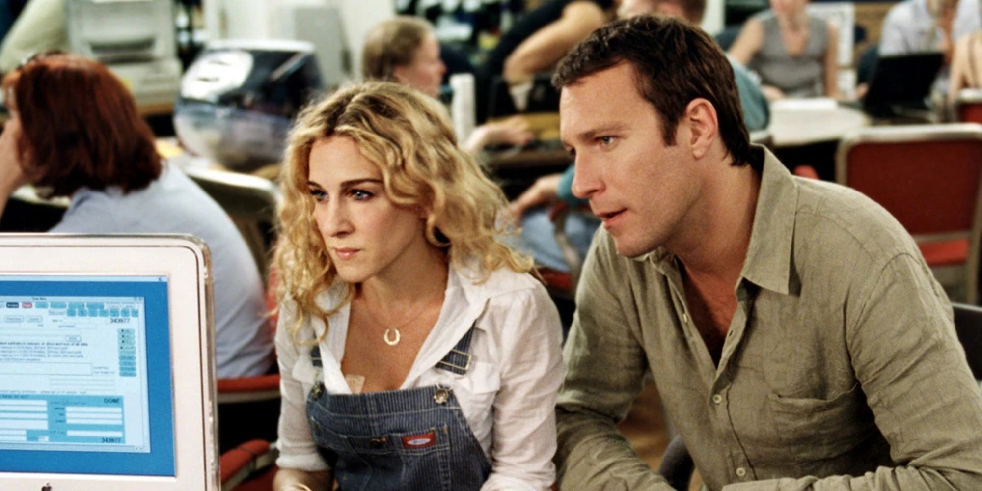 Sarah Jessica Parker sitting next to John Corbett in front of a desk in Sex and the City