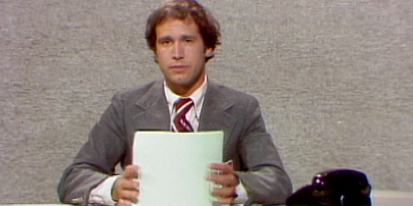 Chevy Chase sits behind the Weekend Update desk on 'Saturday Night Live'.