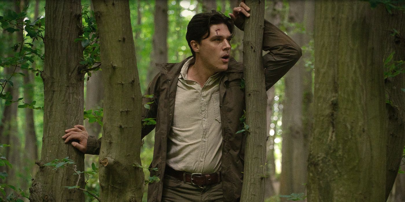 Finn Wittrock as Richard, leaning against a tree with a cut on his forehead in the Netflix thriller Don&rsquo;t Move