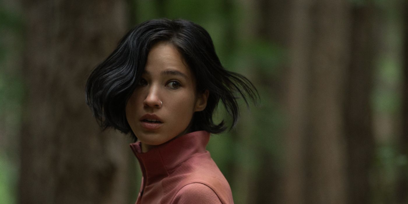 Kelsey Asbille as Iris, standing in the forest and looking behind her in the Netflix thriller Don't Move